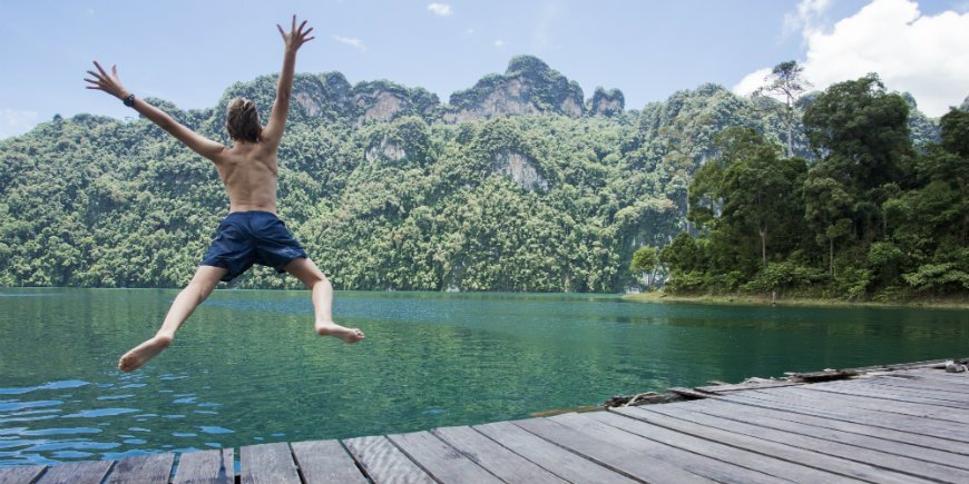 boy jumping in the lake in khao sok thailand