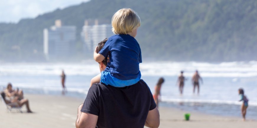 child and father on the beach in Brazil